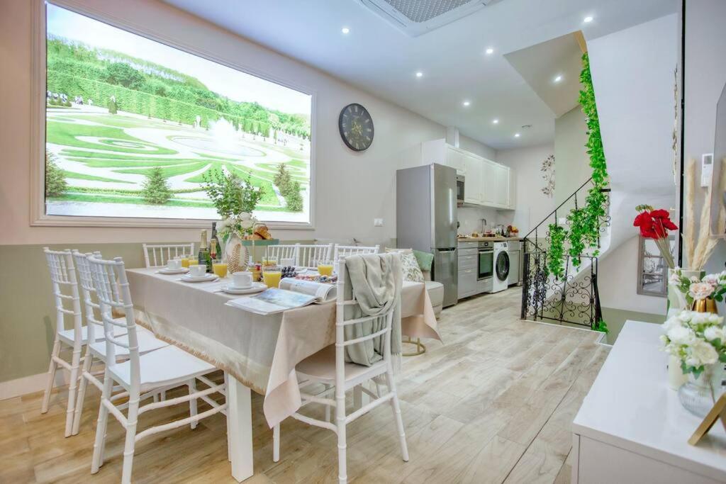 une cuisine et une salle à manger avec une table et des chaises dans l'établissement Le Nid Parisien Triplex Cosy et Chaleureux, à Paris