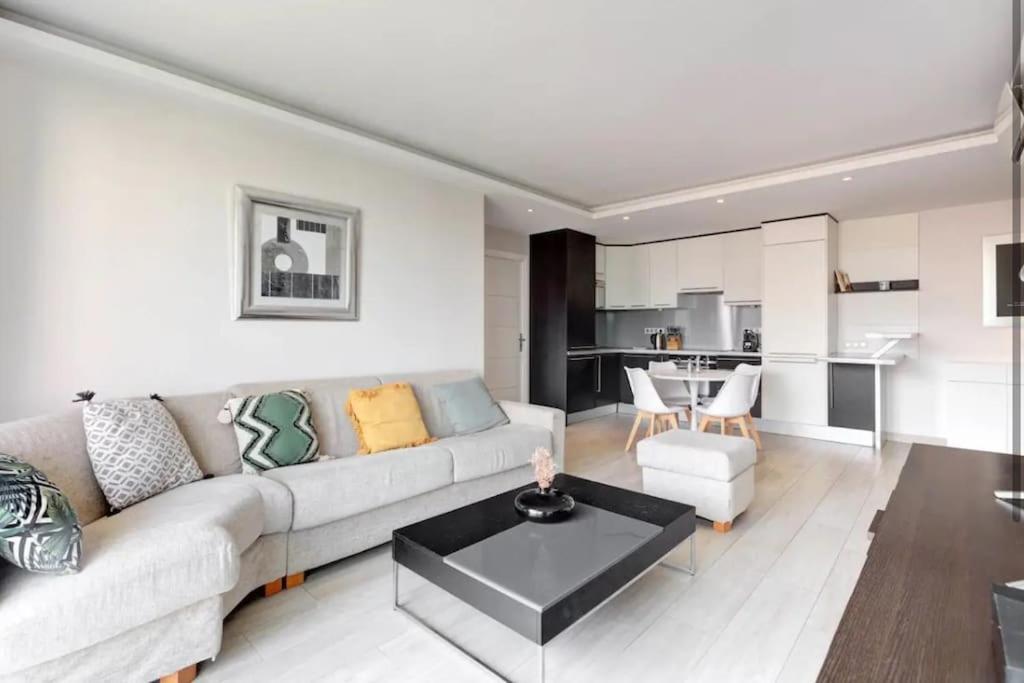 un salon avec un canapé et une table dans l'établissement Cannes Palm Beach - 2 chambres Vue mer, à Cannes