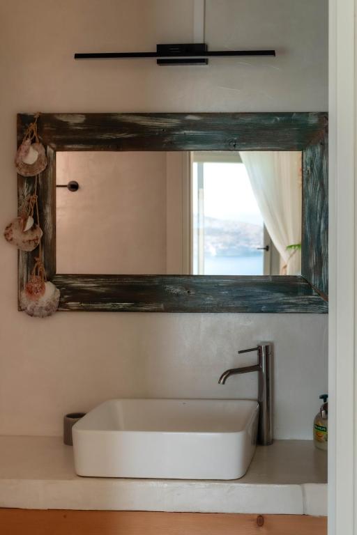 a bathroom with a sink and a mirror at Deja Blue Villa 1 in Agios Georgios