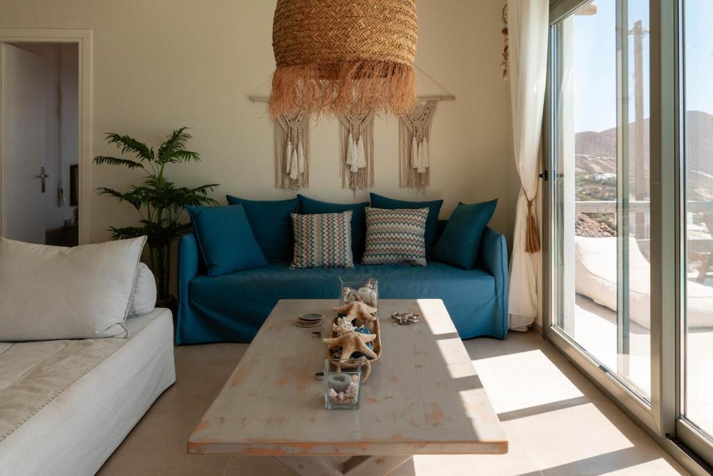 a living room with a blue couch and a table at Deja Blue Villa 1 in Agios Georgios
