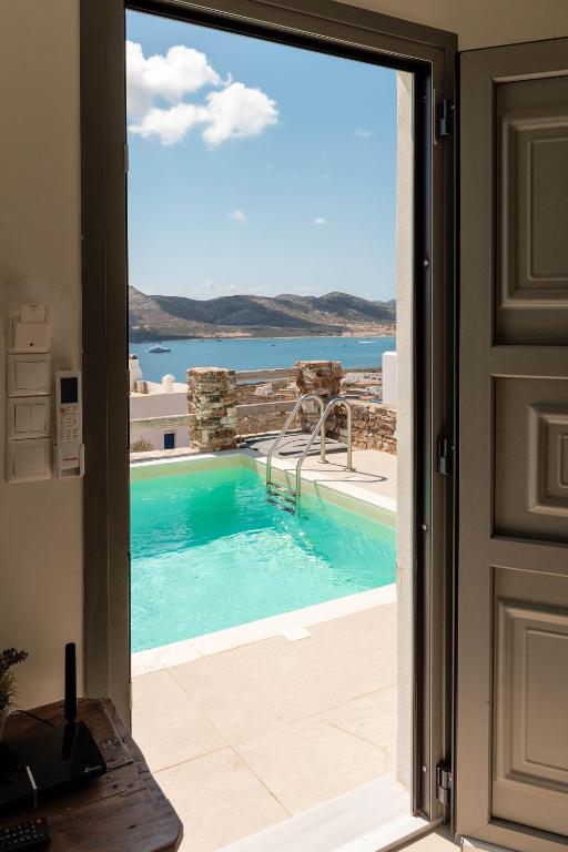 a door leading to a swimming pool with a view at Deja Blue Villa 1 in Agios Georgios