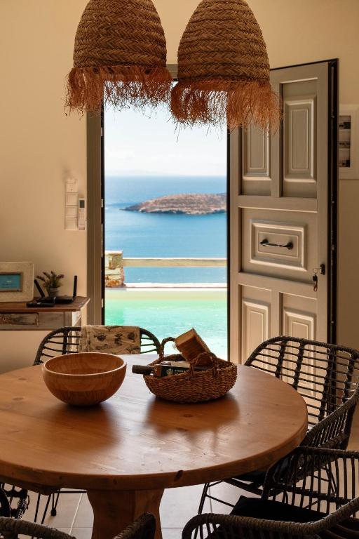 a dining room table with a view of the ocean at Deja Blue Villa 1 in Agios Georgios