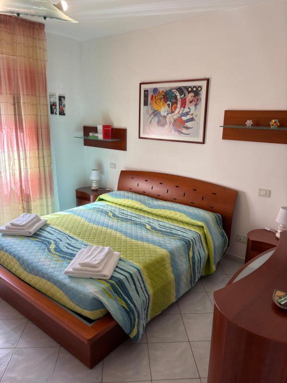 a bedroom with a bed with two towels on it at Poetto Casa Bach Ck in Quartu SantʼElena