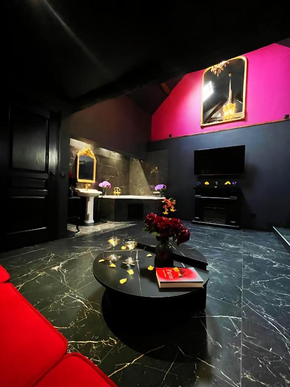 un salon avec une table et une cheminée dans l'établissement L'Orchidarium, maison élégante et romantique à Flagy, à Flagy