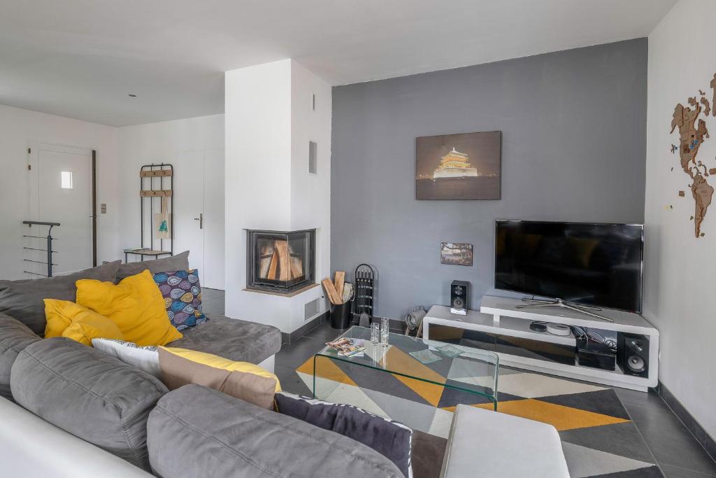 un salon avec un canapé et une télévision dans l'établissement Maison pour 6 à 900m de la plage, à Saint-Brévin-les-Pins