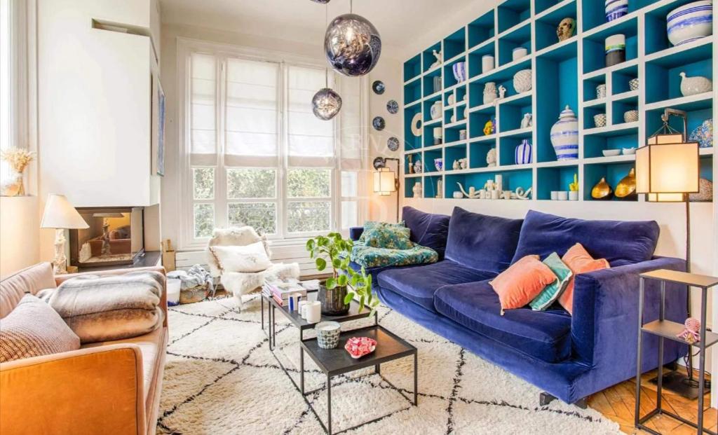 un salon avec un canapé bleu et un mur bleu dans l'établissement 77 VH - Villa piscine - plein centre, à Deauville