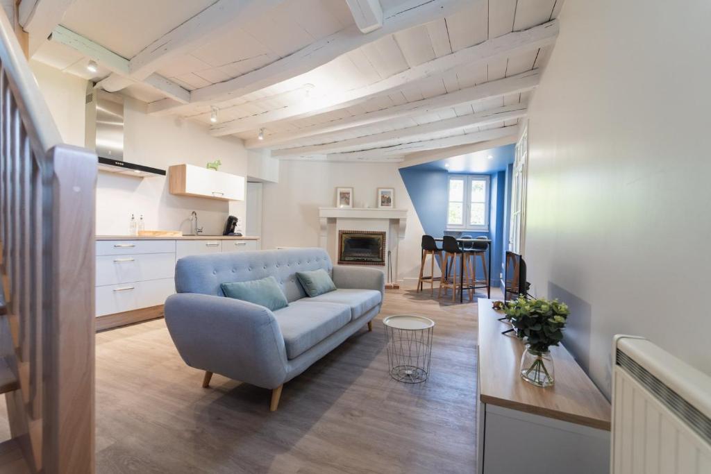 un soggiorno con divano e cucina di Le Petit Verger, cosy 5 people a Vivonne