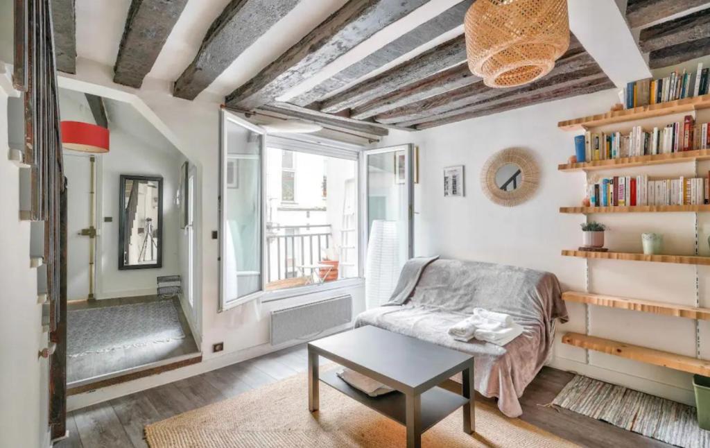 un salon avec une chaise et une fenêtre dans l'établissement GuestReady - Bright Stay in the Heart of Paris, à Paris