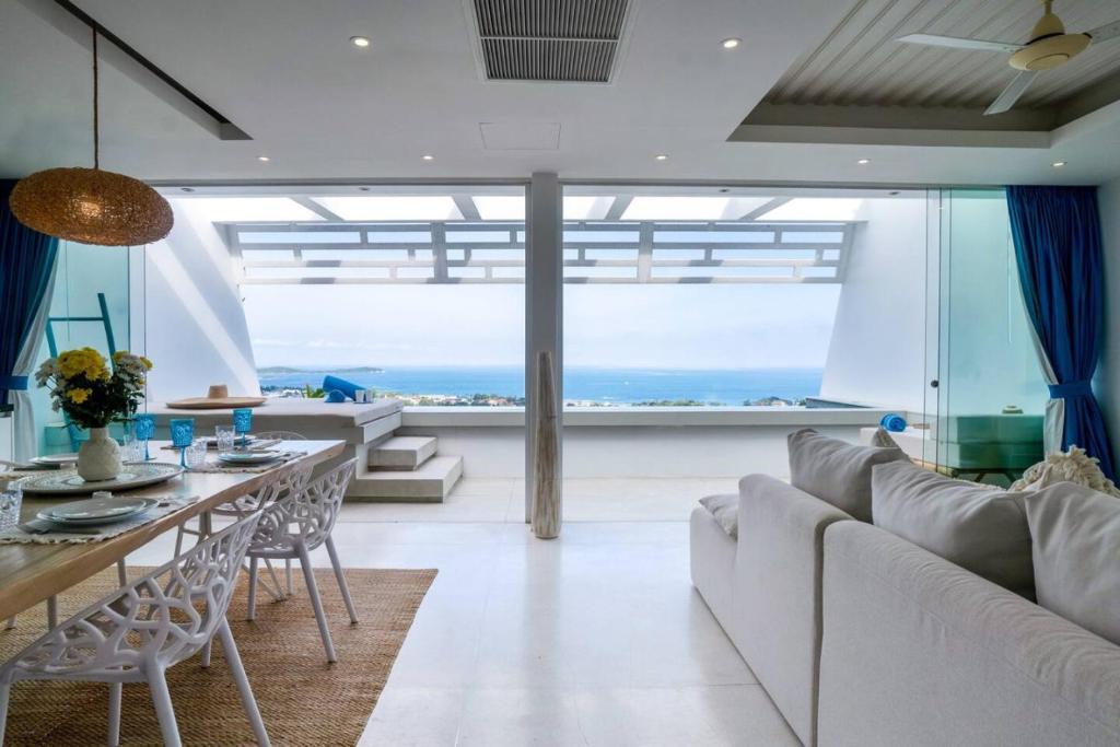 班阁库安Ocean Serenity 3 bd inifity pool with unreal views的客厅配有白色的沙发和桌子