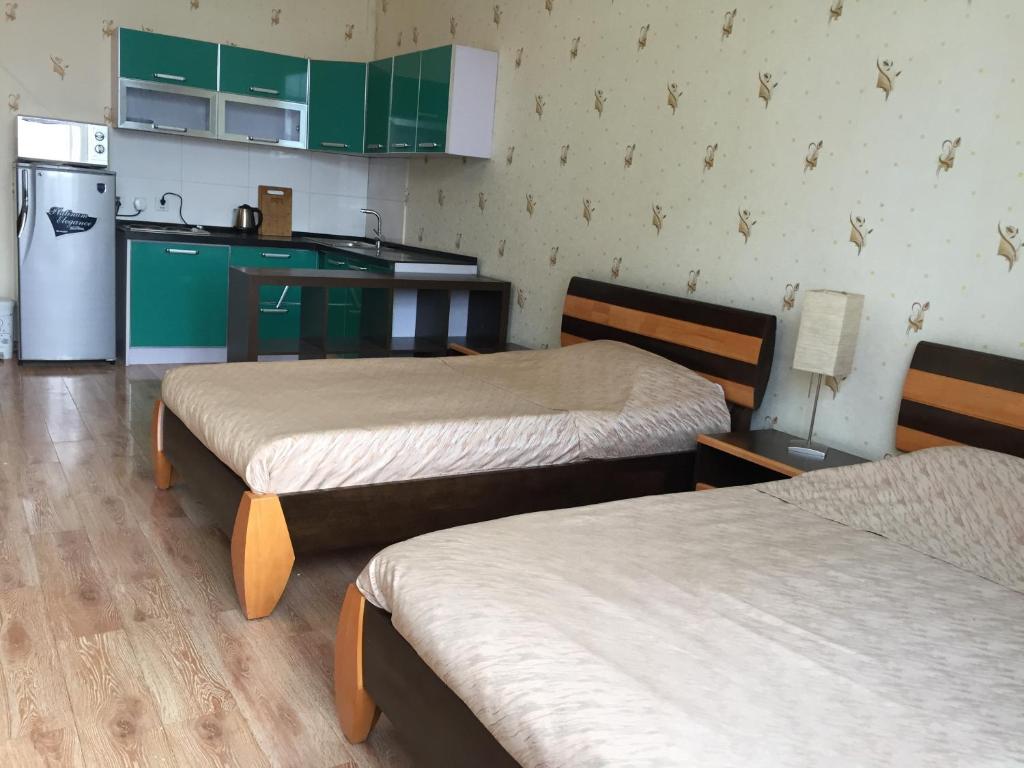 Habitación con 2 camas y cocina con nevera. en Tsolmon's Serviced Apartments en Ulán Bator