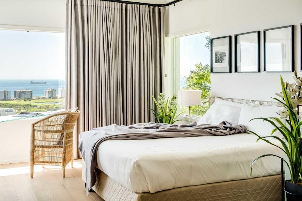 a bedroom with a bed and a large window at Ocean Vue in Cape Town