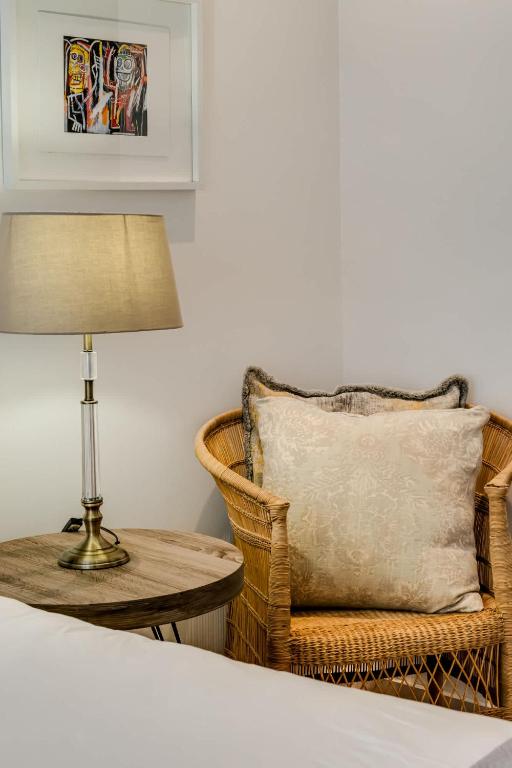 a bedroom with a table and a chair and a lamp at Ocean Vue in Cape Town