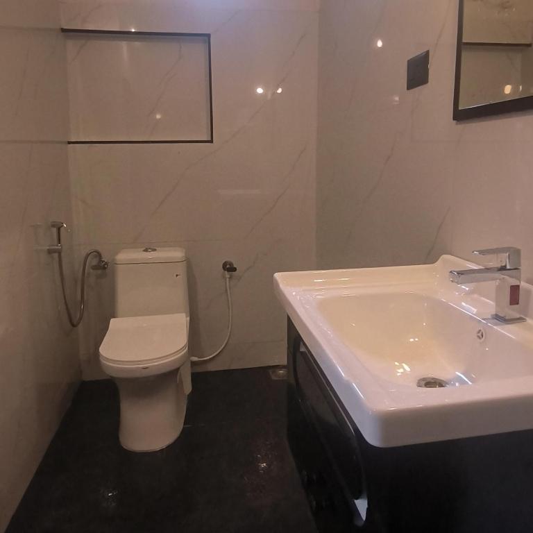 a bathroom with a white toilet and a sink at Mad about Coco Yoga & Beach Retreat in Varkala