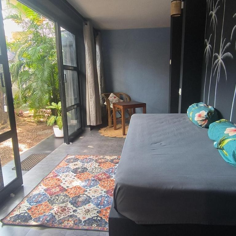 a bedroom with a bed and a view of a patio at Mad about Coco Yoga & Beach Retreat in Varkala
