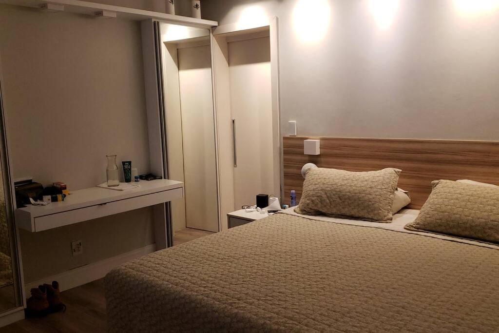 a bedroom with a large bed and a sink at Praia Xangri-lá Atlântida Capão da Canoa Torres in Xangri-lá