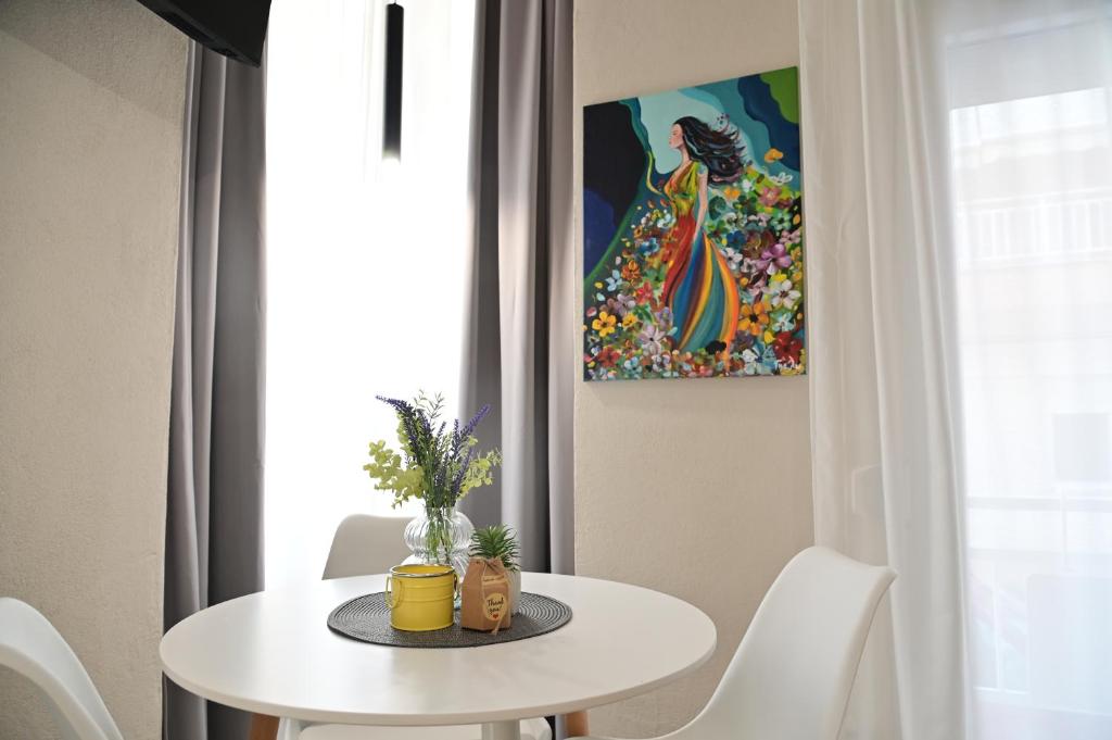 a white table and chairs in a room with a painting at Valia's Elegance Stays in Alexandroupoli