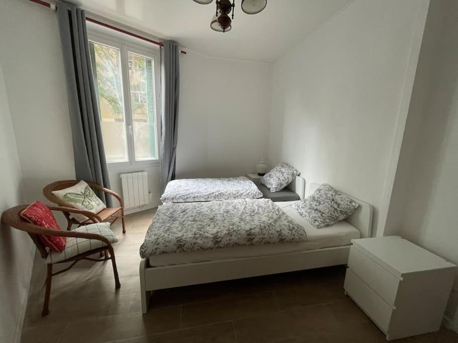 une chambre avec un lit, une chaise et une fenêtre dans l'établissement Appartement Charpenne, à Villeurbanne