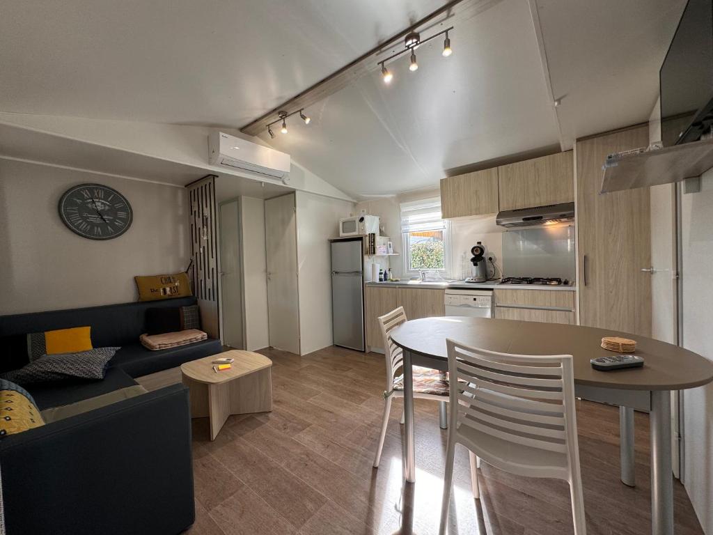 a kitchen and a living room with a table and chairs at Bungalow à capbreton - Terrasse in Capbreton