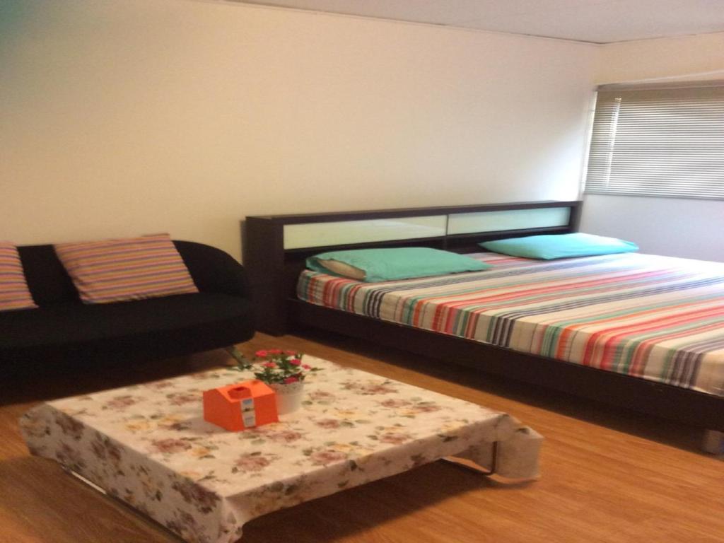 1 dormitorio con cama y mesa de centro en Poppular Palace Don Mueang Bangkok, en Bangkok