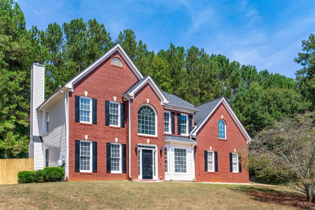 une grande maison en briques rouges sur une cour dans l'établissement Relaxing home close Six Flag 21 miles to airport, à Mableton