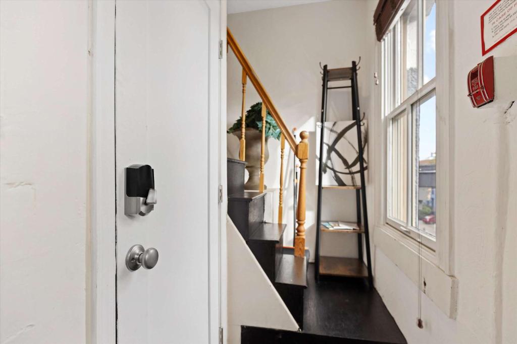 a hallway with stairs in a house with a door at Chic 1-BR Loft Nestled Between Dupont & Logan in Washington, D.C.