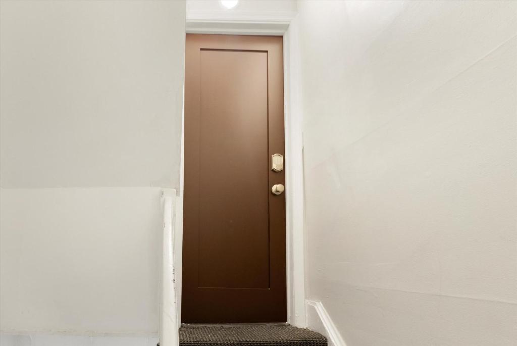 a corridor with a brown door in a white room at Chic 1-BR Loft Nestled Between Dupont & Logan in Washington, D.C.