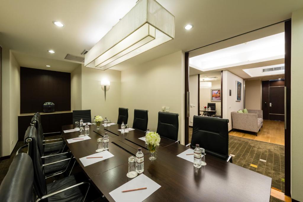 A private meeting room has a long boardroom table prepared for a formal meeting.