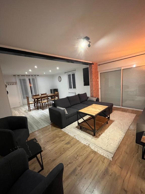 a living room with a couch and a table at l'HIRONDELLE in Les Goths
