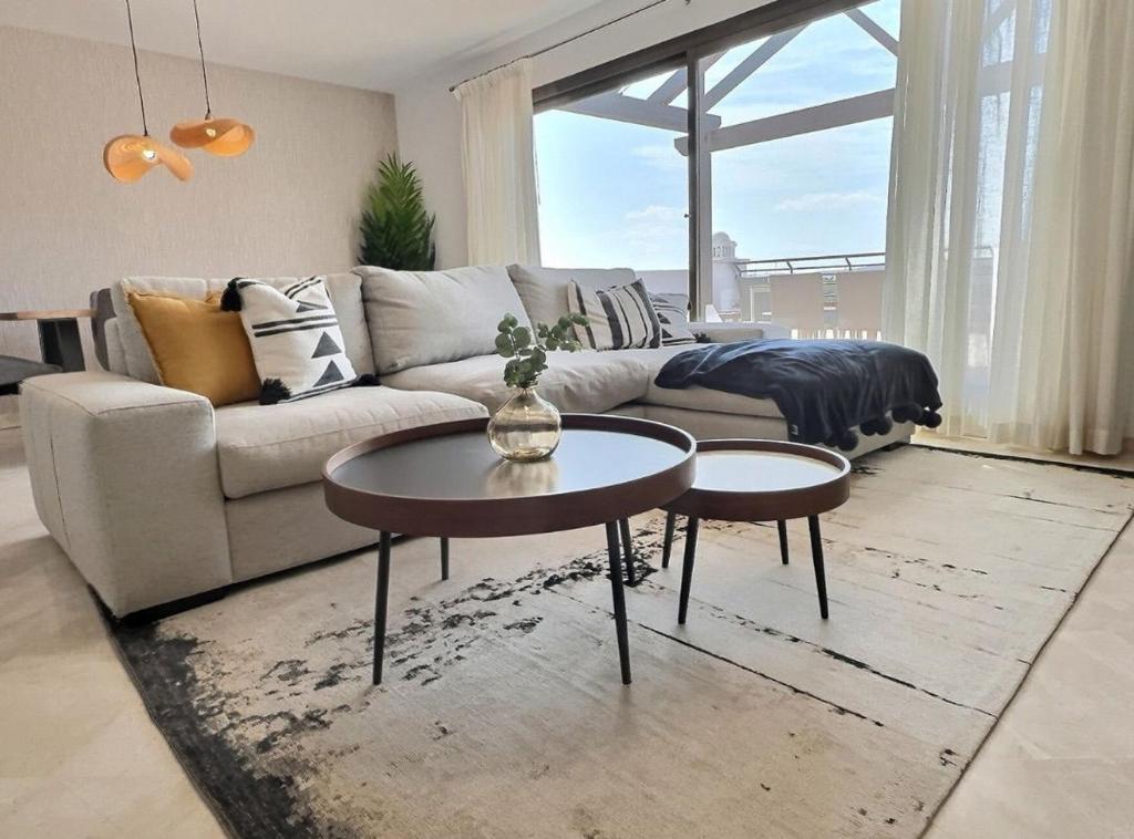 a living room with a couch and two tables at Gorgeous 3-Bedroom Penthouse with Expansive Terrace in Casares Costa in Buenas Noches