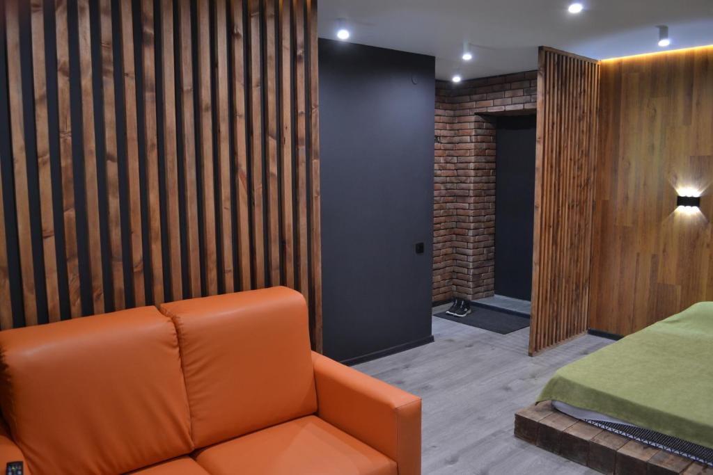 a living room with a couch and a bedroom at 1комн лофт в центре in Semey