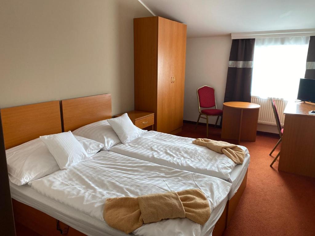 a bedroom with a bed with a towel on it at Hotel Černý Orel Žatec in Žatec