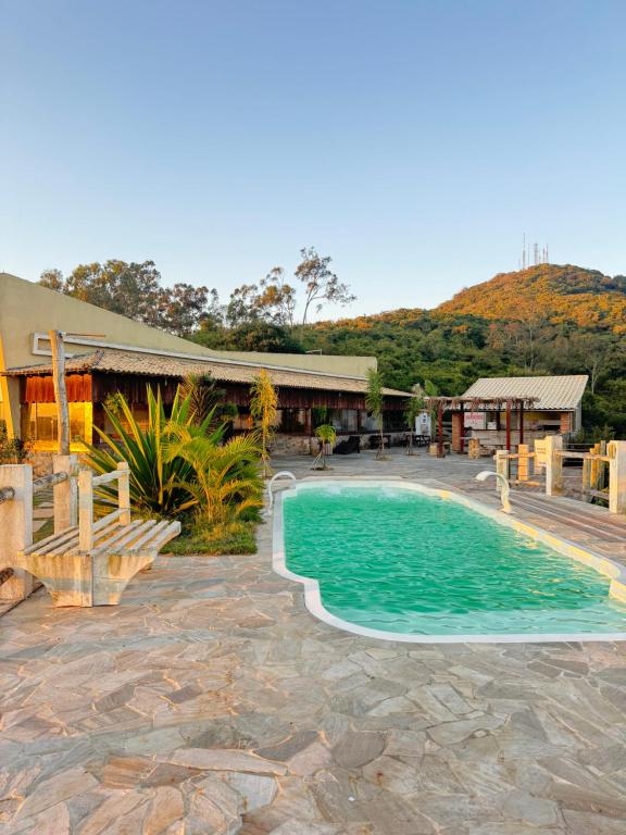 a swimming pool in a yard next to a building at Pousada Fazendinha Beach Club Arraial do Cabo in Arraial do Cabo