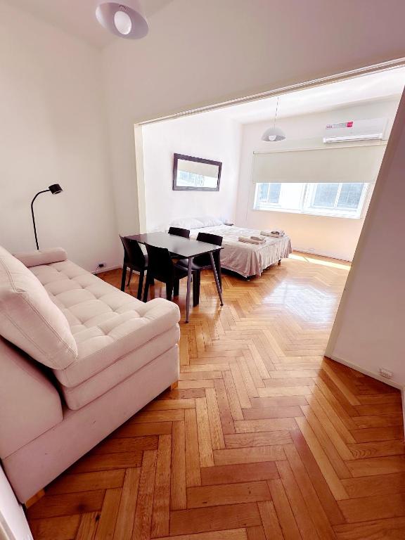 a living room with a white couch and a table at Amplio monoambiente en Microcentro in Buenos Aires