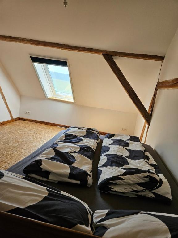 two beds in a room with a window at Unterkunft , Ferienwohnung auf dem Land, Monteurswohnung in Kamenz