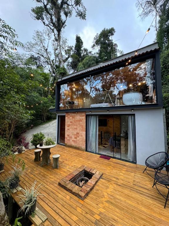 a house with a wooden deck with a fire pit at Cabana Entre Árvores- Lavanda in Rancho Queimado