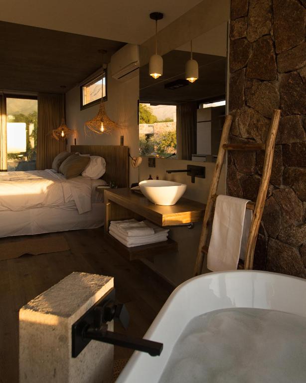 Habitación con baño con cama y bañera. en La Singladura, en La Población