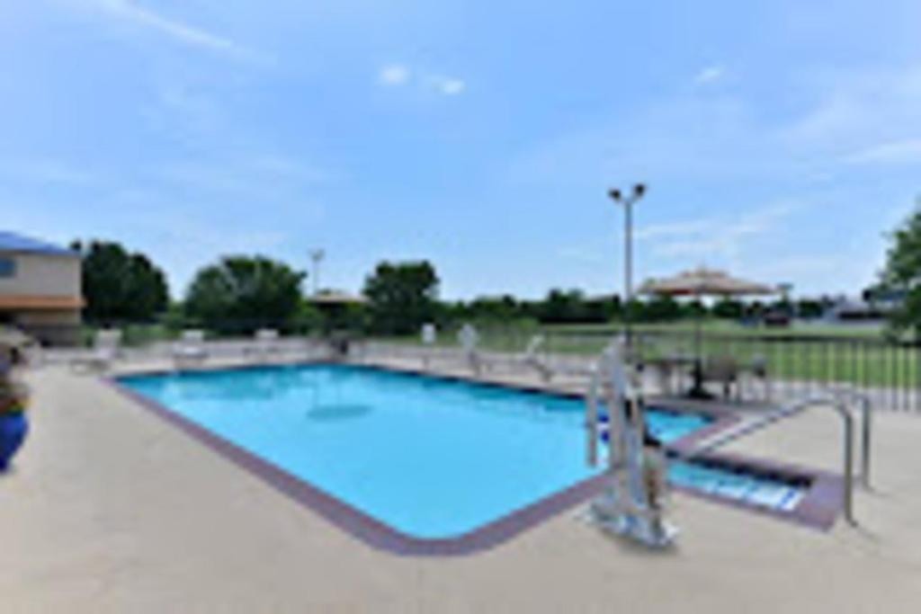 a large swimming pool with blue water at Baymont by Wyndham Ardmore I-35 in Ardmore