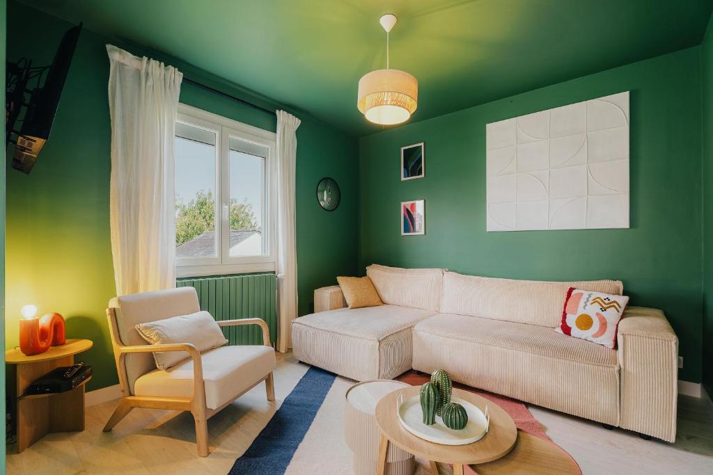 - un salon avec des murs verts et un canapé dans l'établissement Maison 12 personnes, grand jardin, proche plages, animaux acceptés par Maison ELANORE, à Pleurtuit