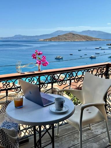 a laptop on a table on a balcony with a view of the water at Maestro apartment Chalki in Halki