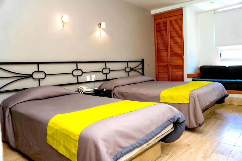 Postel nebo postele na pokoji v ubytování Hotel Arboledas Expo
