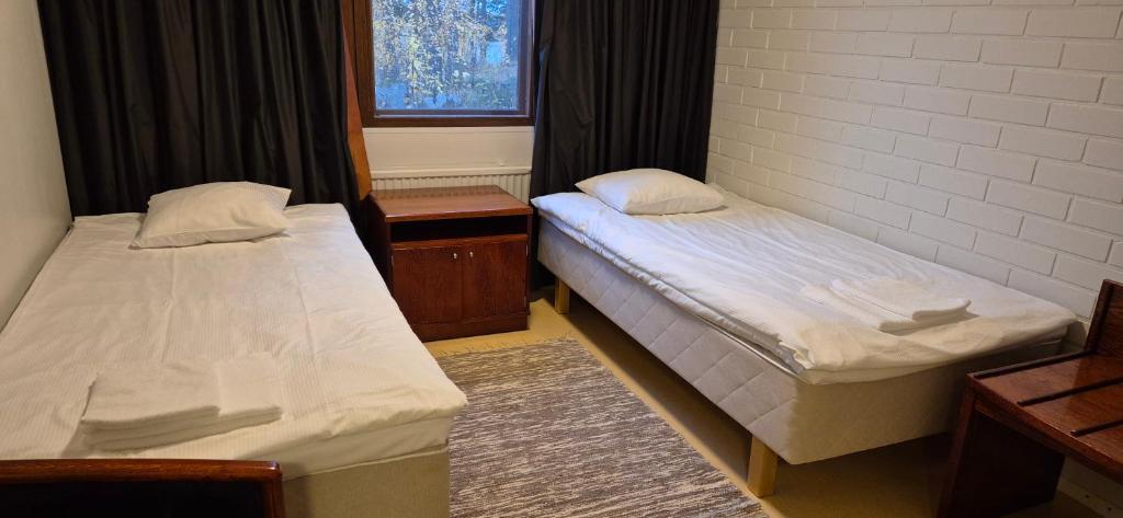 Dos camas individuales en una habitación con ventana. en Spacious 4BR Apartment Särkilahti, en Savonlinna