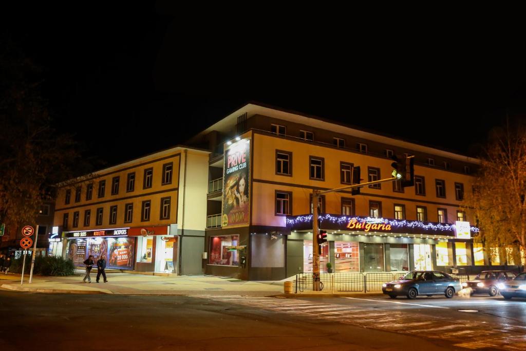 un edificio en la esquina de una calle por la noche en Hotel Bulgaria en Kŭrdzhali