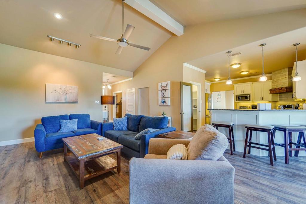a living room with blue couches and a kitchen at Spacious Lubbock Home with Private Pool and Yard! in Lubbock