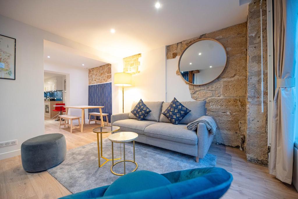 un salon avec un canapé et un miroir dans l'établissement Beautiful Apartment in Saint Germain, à Paris