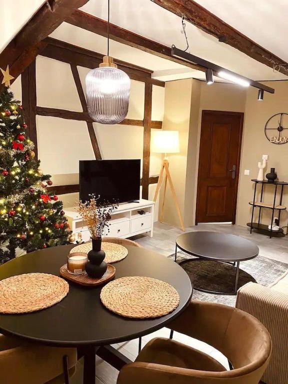 un salon avec un arbre de Noël et des tables dans l'établissement À la petite Venise hyper centre Colmar, à Colmar