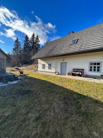 a white house with a grassy yard in front of it at Gorjuška Rozamunda in Bohinjska Bistrica