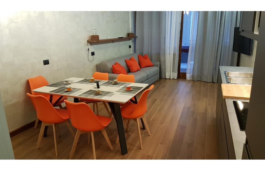 salon ze stołem i pomarańczowymi krzesłami w obiekcie Orange Fox Cervinia apartment Vda Vacanze in Vetta CIR 0185 w mieście Breuil-Cervinia