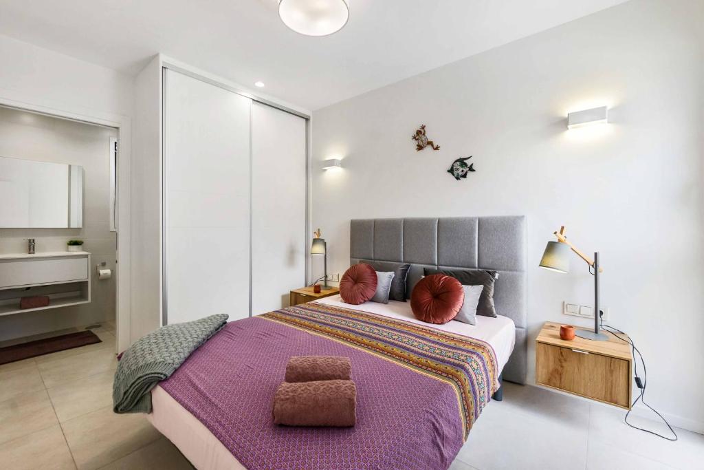 a bedroom with a large bed with a purple blanket at Turquesa del Mar - Charming Ground-Floor Spanish Apartment with Large Sunny Terrace in Orihuela Costa