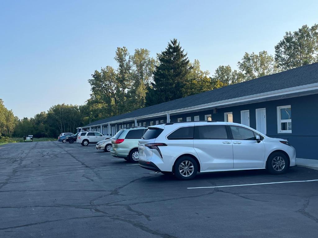 a row of cars parked in a parking lot next to a building at Eastcourtmotel in Sarnia