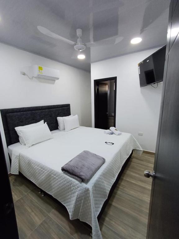 a bedroom with a white bed with a pillow on it at Hotel Internacional Boutique Milan in Puerto Boyacá